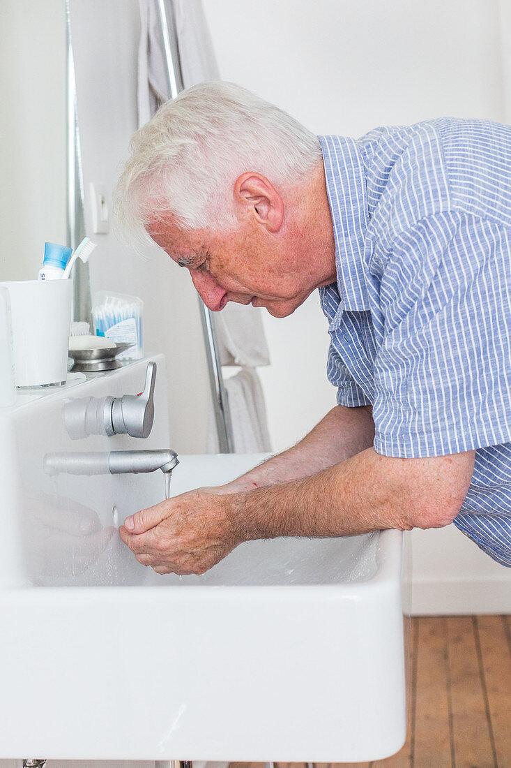 Man splashing water over his face