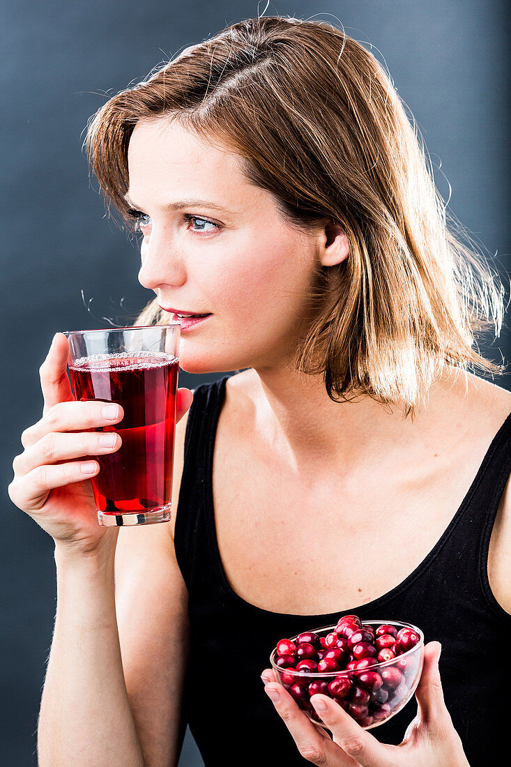 Woman drinking a glass of cranberry juice