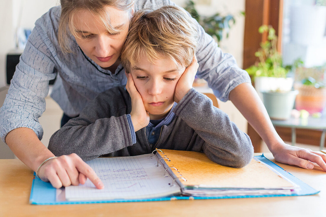 Boy doing homework with his mother