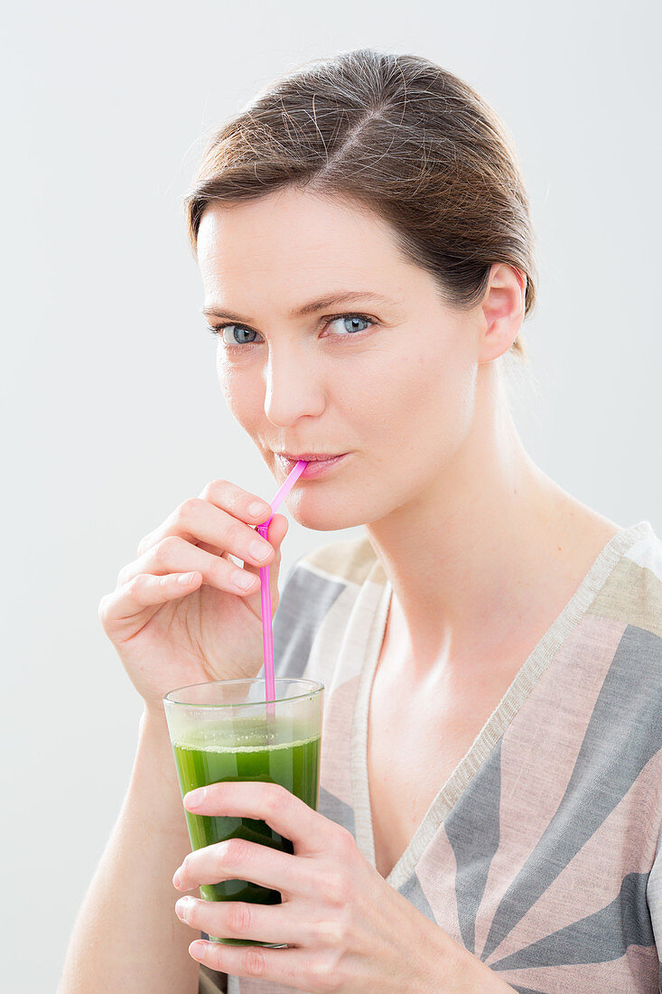 Woman drinking a wheat grass juice