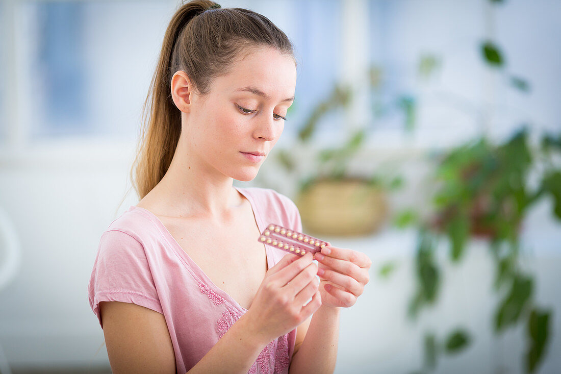 Woman holding oral contraception pills