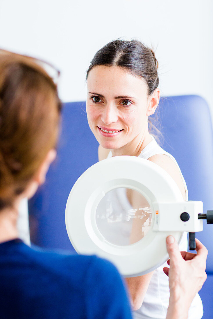 Doctor examining the skin of a woman