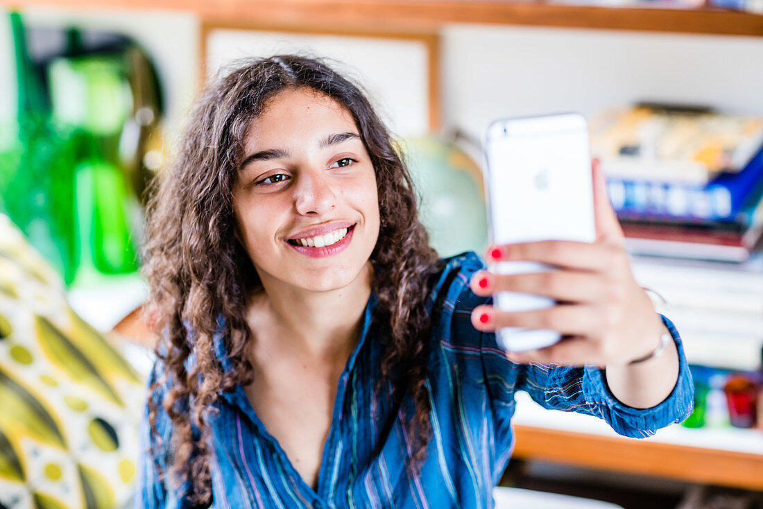 Teenage girl taking picture with camera phone