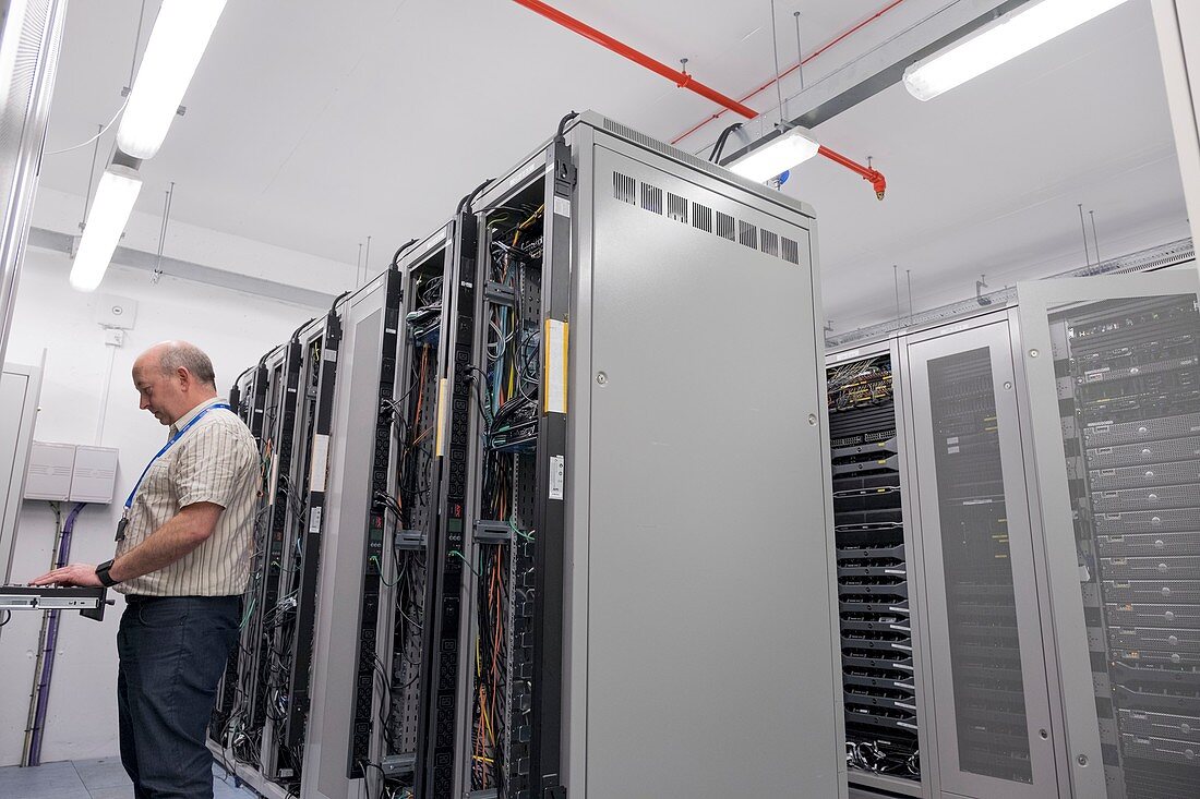 Technician checking servers in data centre