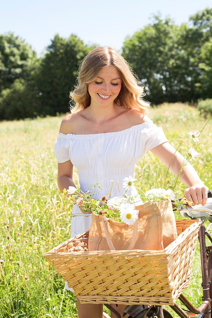 Woman in meadow with bicycle