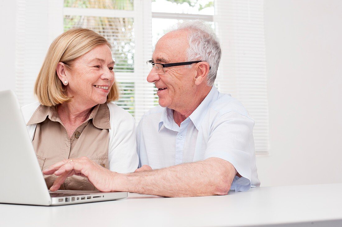 Senior couple using laptop