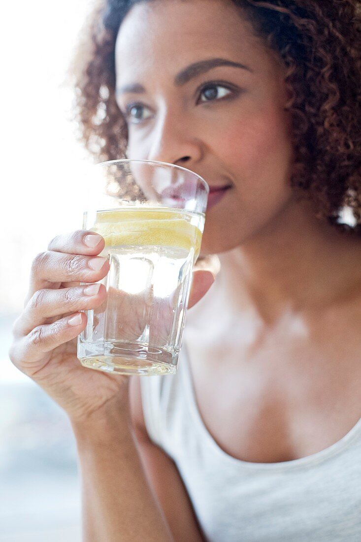 Mid adult woman drinking water