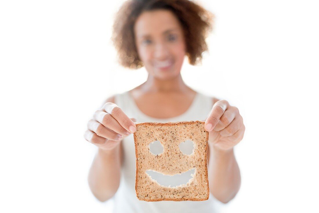 Woman holding bread with smiley face