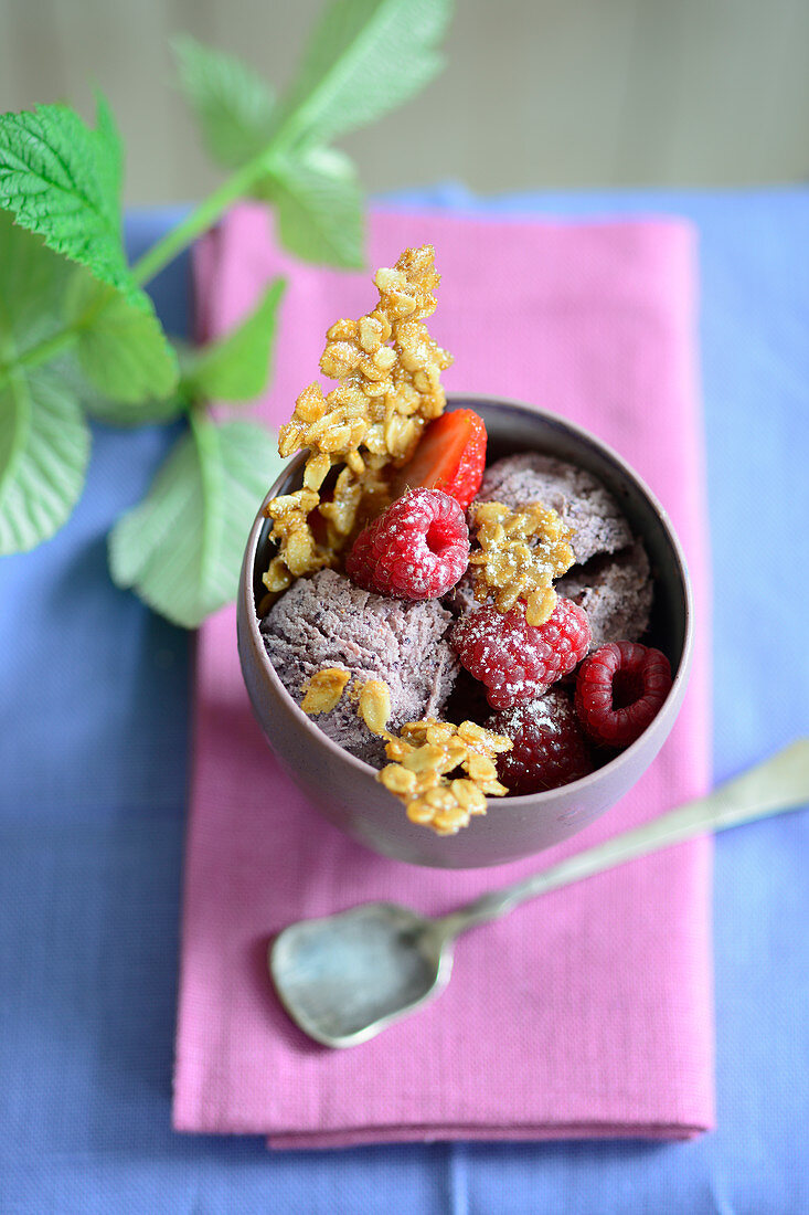 A muesli ice cream sundae with raspberries and oats