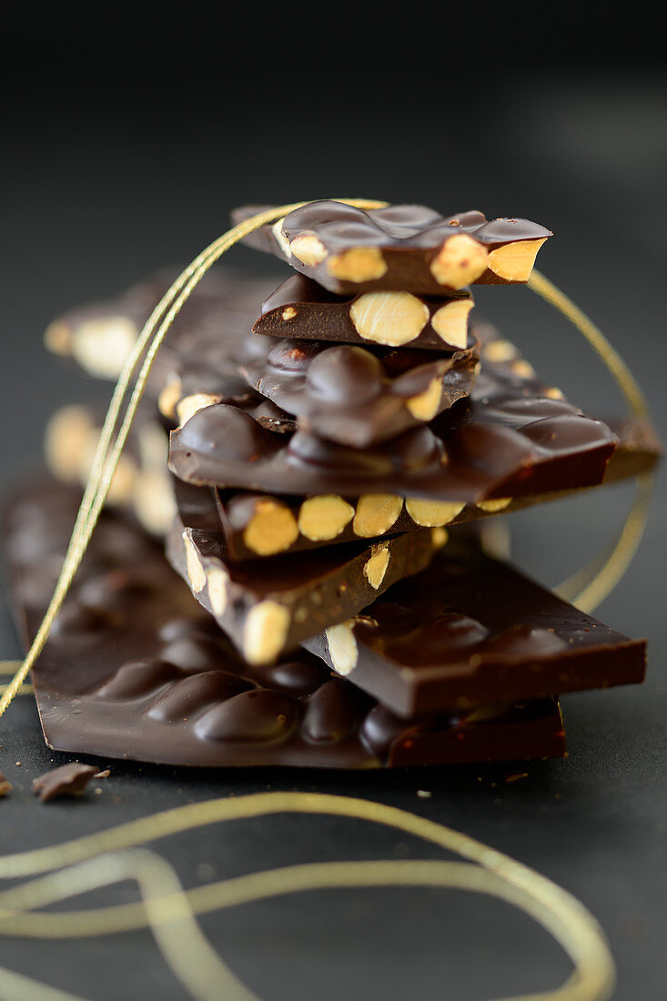 Einige Stucke Schokolade mit Mandeln übereinander gestapelt
