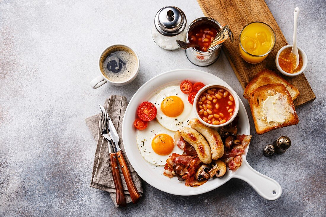 Englisches Frühstück mit Eiern, Würstchen, Speck, Bohnen und Toast