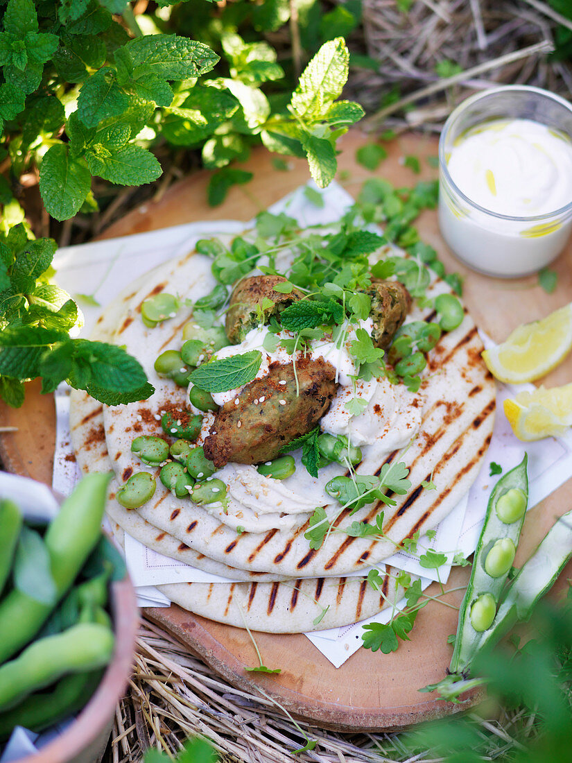 Falafel mit Tahini-Sauce und Kräutern auf Pitabrot