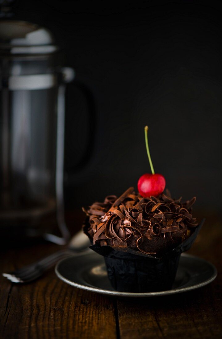 A chocolate cupcake with a cherry