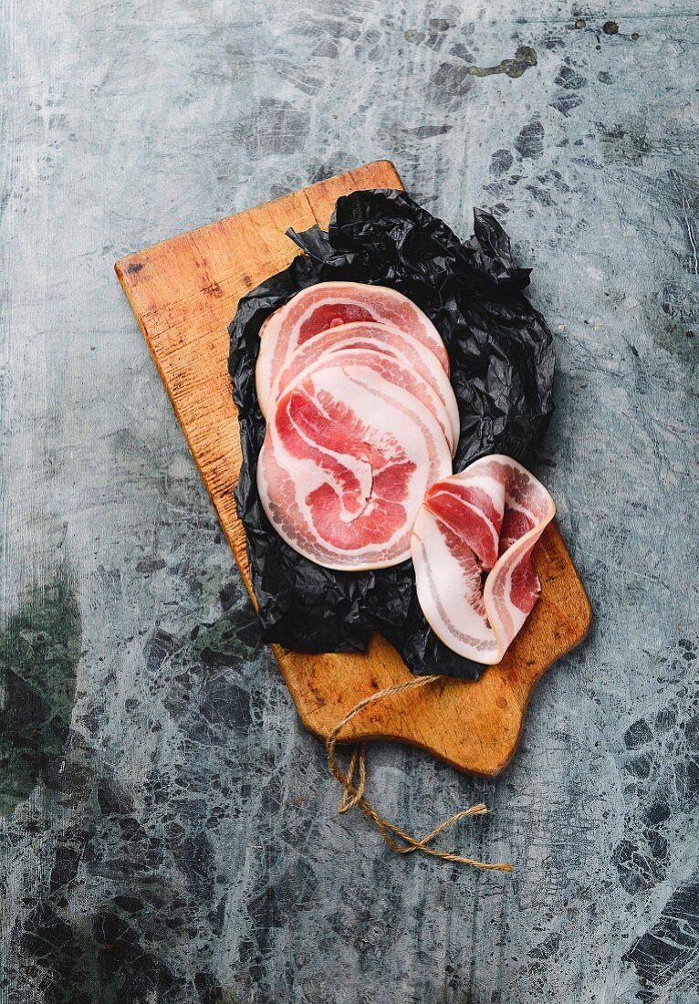 Slices of pancetta on a wooden board