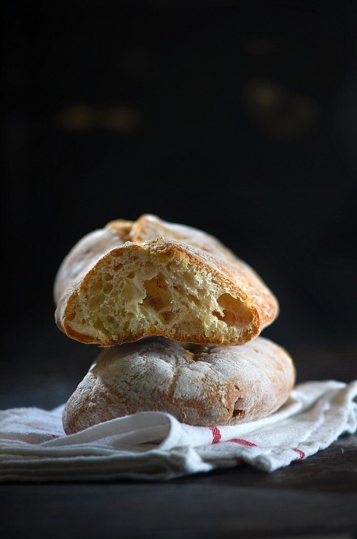 Ciabatta, whole and sliced, on a tea towel