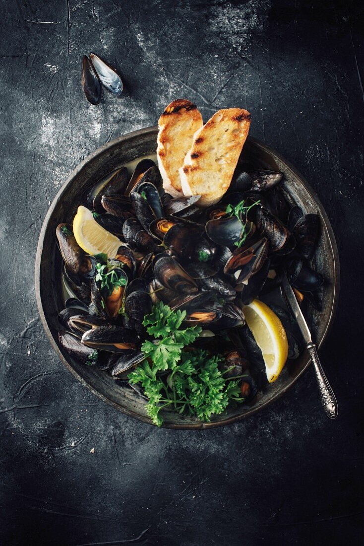 Mussels in a white wine broth with lemon, parsley and toasted bread