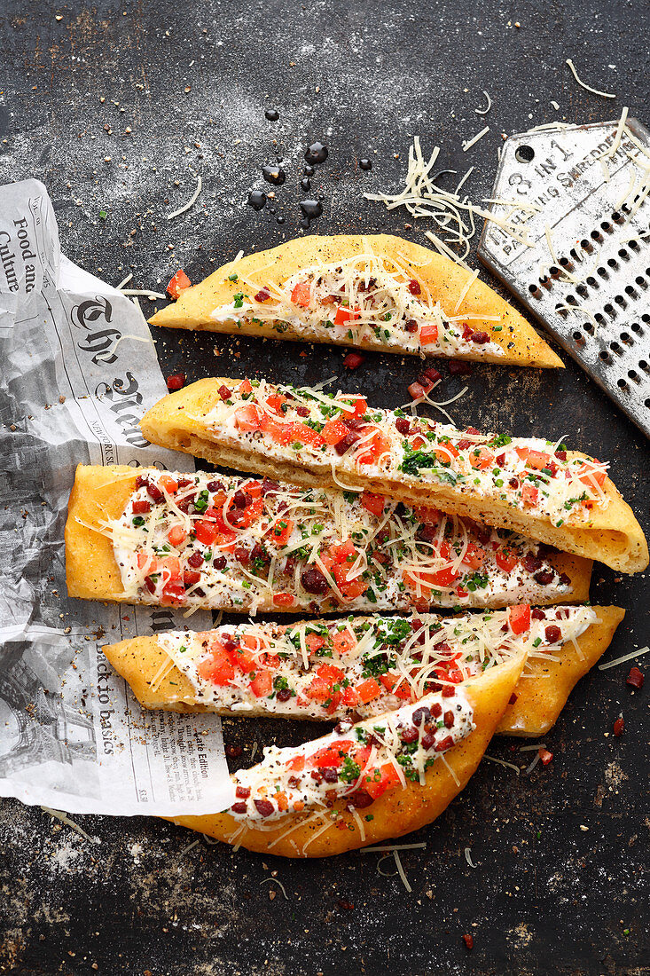 Langos (fried, unleavened potato bread with bacon, mountain cheese and sour cream)