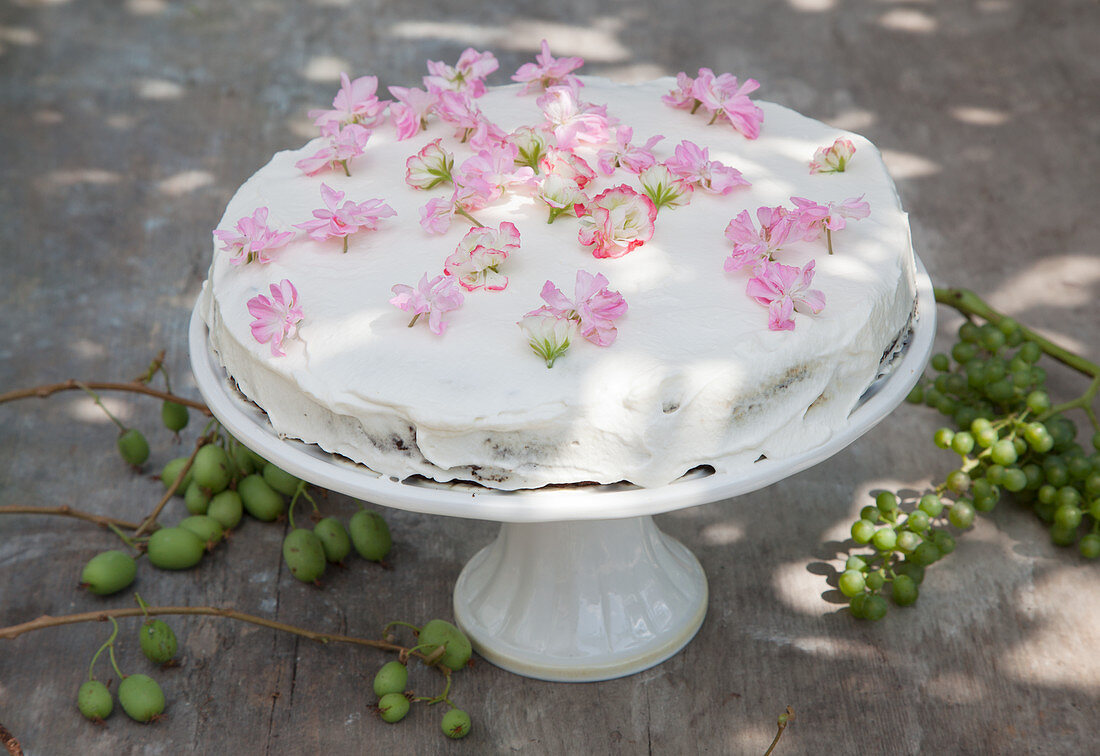 A cake decorated with edible lemon geraniums