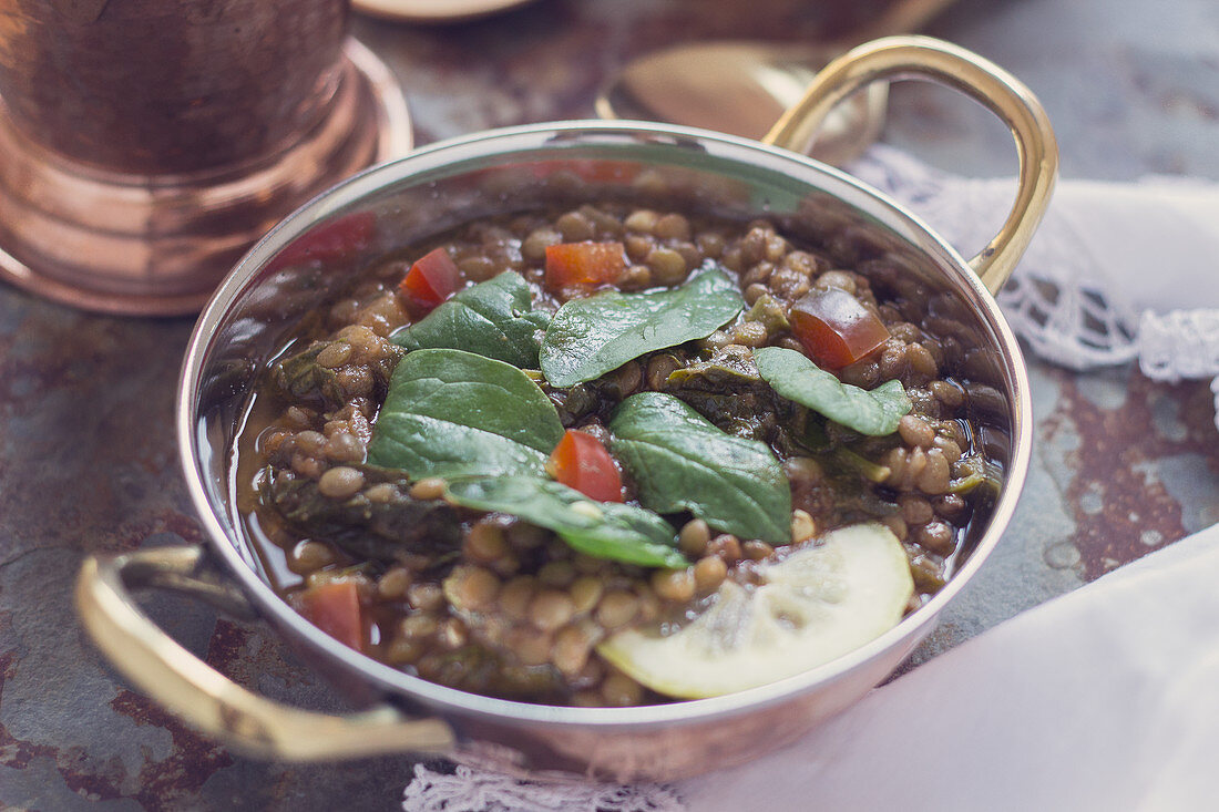 Lentil spinach curry in a copper pan