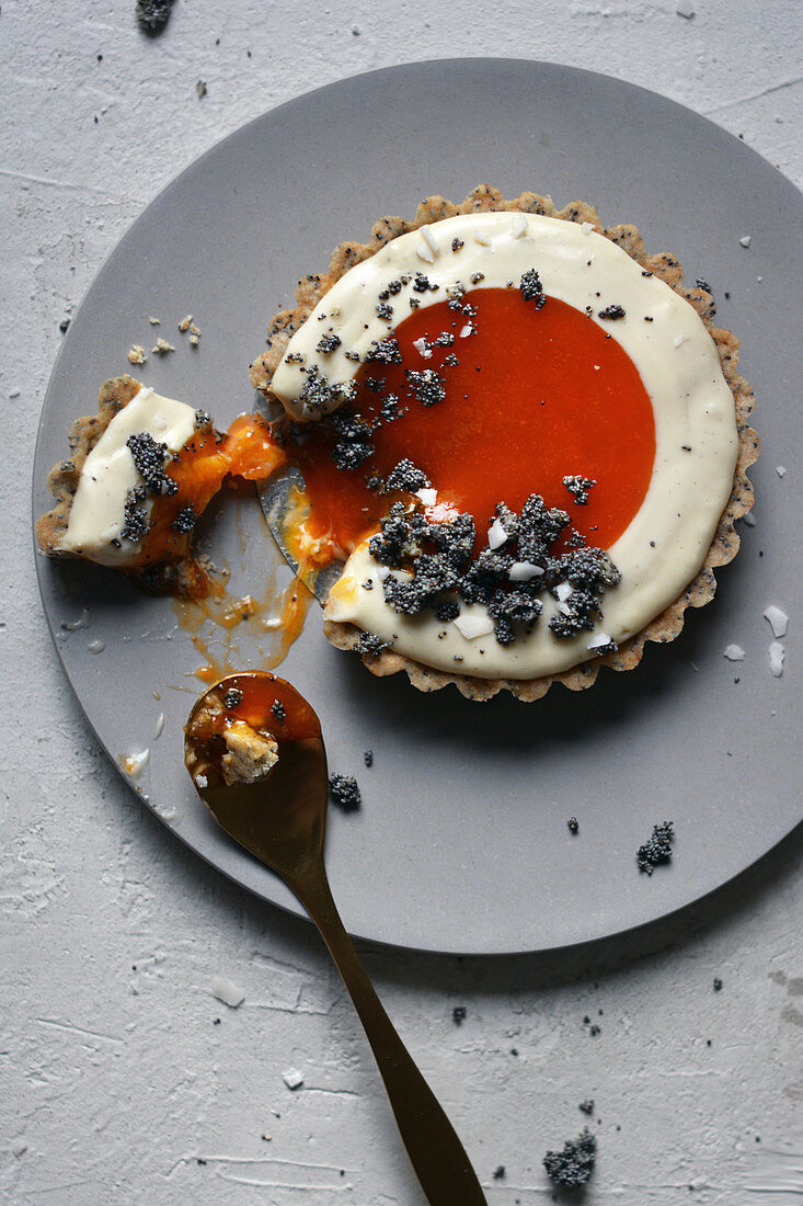 A partially eaten apricot and poppy seed tart
