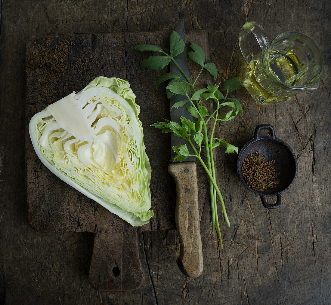 A halved pointed cabbage with loveage, rapeseed oil and caraway