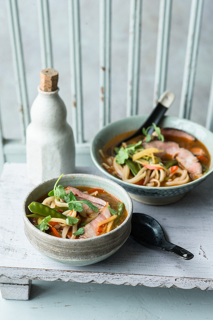 Oriental rice noodle soup with honeyed meat