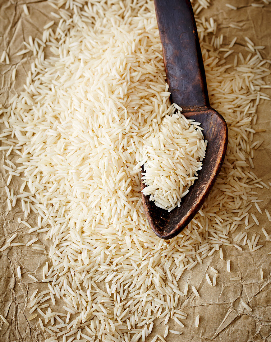 Uncooked rice with a wooden spoon