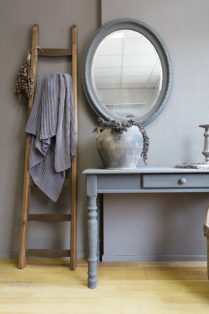 Ladder next to console table in elegant, rustic interior