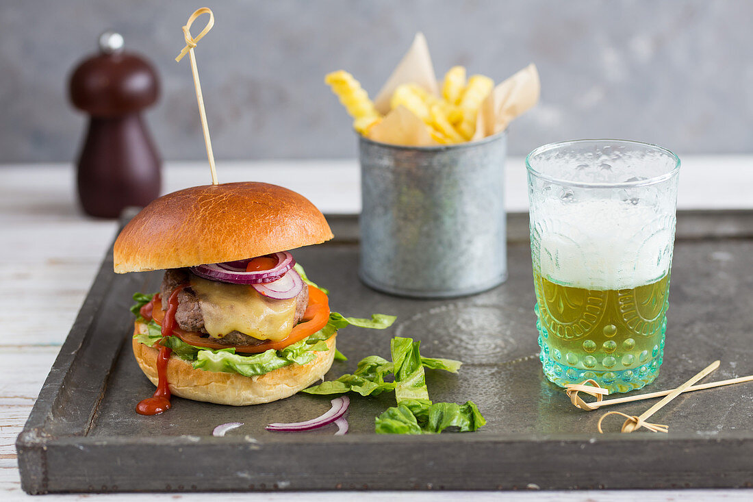 A cheeseburger with chips and beer