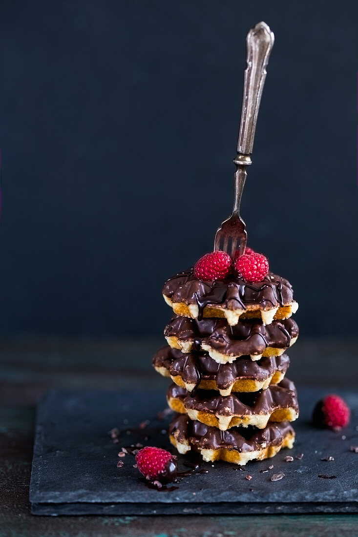 Stacked waffle with chocolate sauce and raspberries