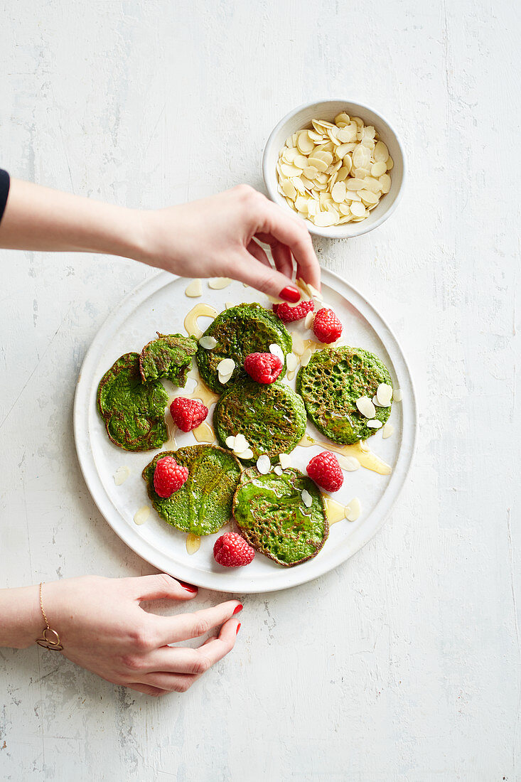 Green spinach 'Popeye' pancakes with raspberries