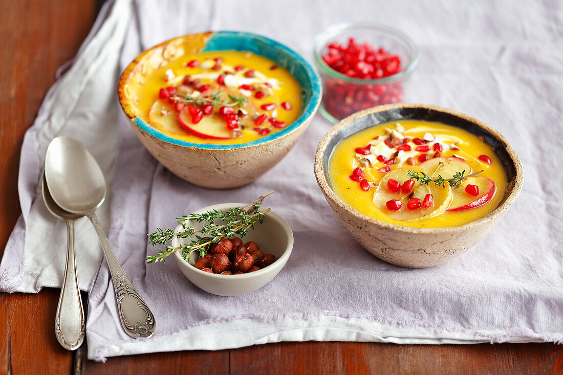 Pumpkin and sweet potatoes cream soup with apples and pomegranate