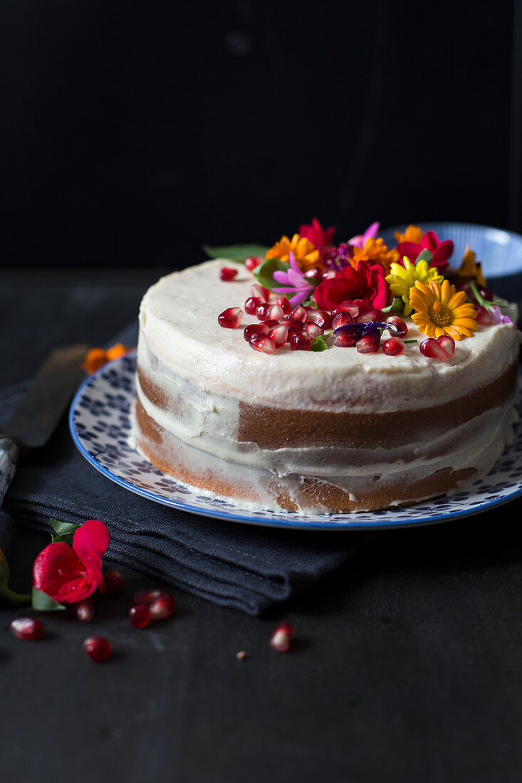 A 'naked cake' with edible flowers and pomegranate seeds