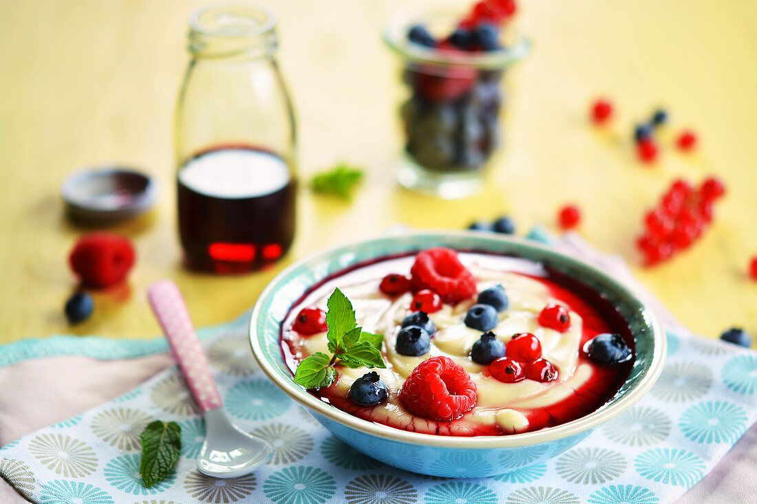 Vanillepudding mit frischen Früchten und Fruchtsirup