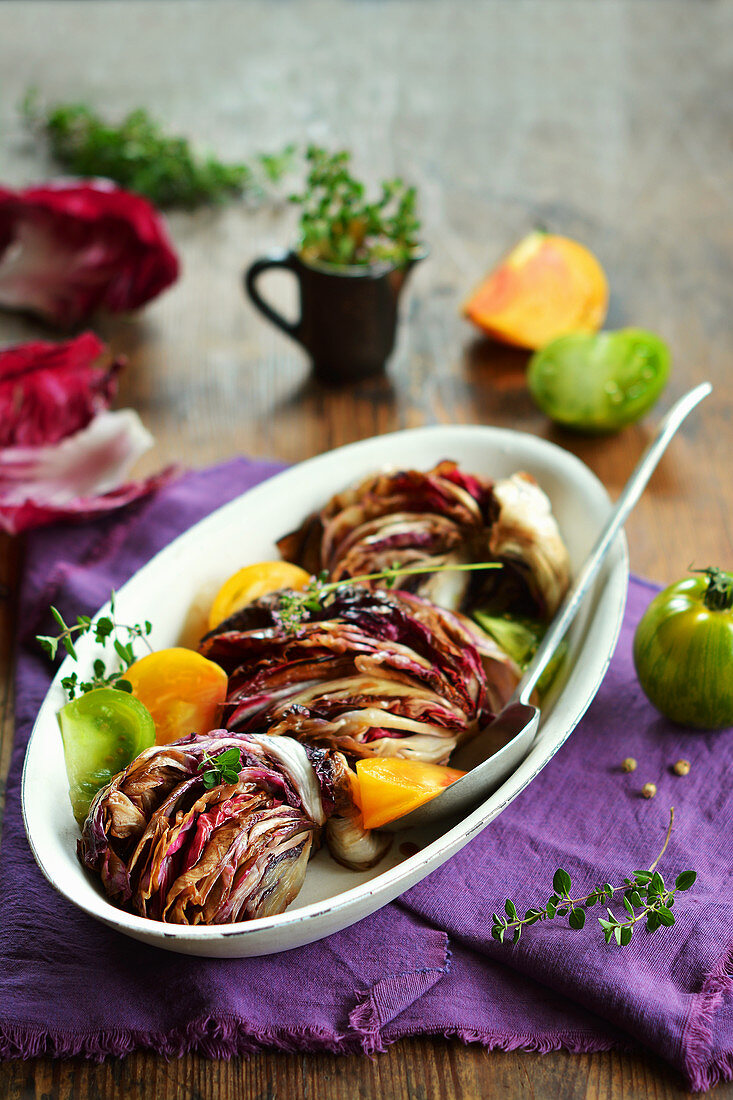 Fried radicchio with fresh tomatoes and herbs in a bowl