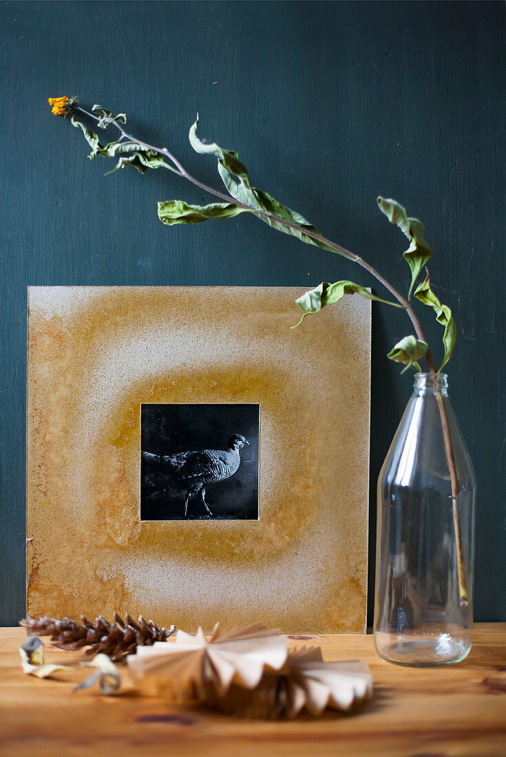 Black-and-white photo in hand-made frame and dried flowers in bottle