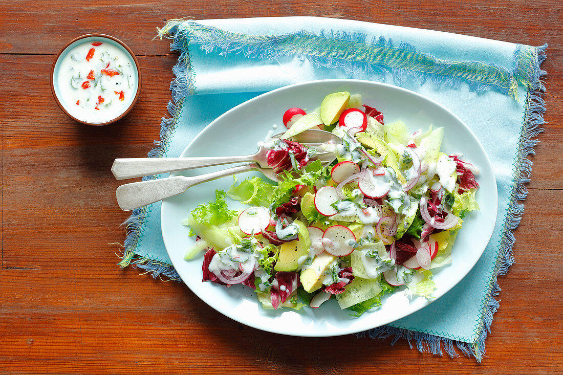 Avocado, cucumber and radishes salad with kefir dressing with chili and herbs