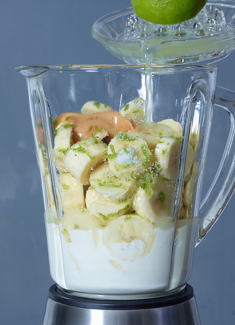 Ingredients for frozen yoghurt with bananas, limes and peanut cream in a blender