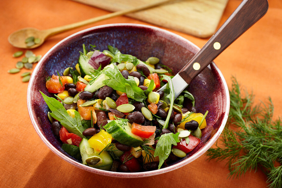 Vegan black bean salad with pepper and pumpkin seeds