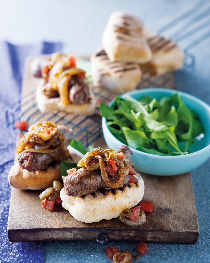 'Roosterkoek' (bread rolls) with 'Boerewors' (a type of sausage) and curried onions (South Africa)