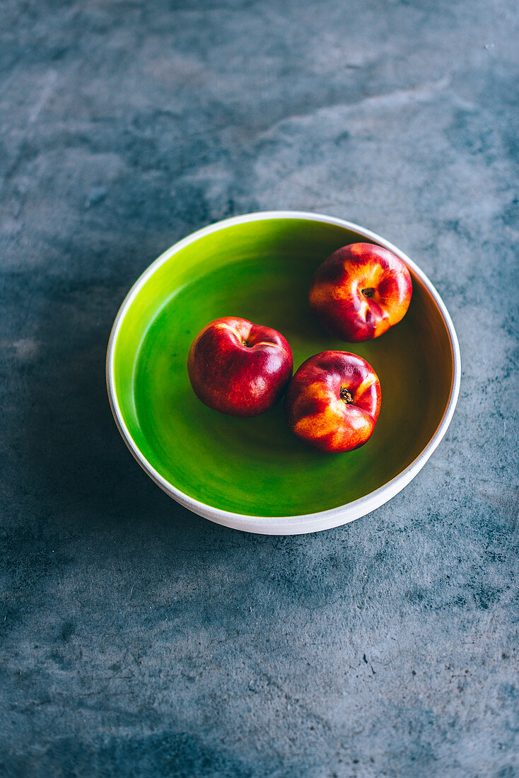 Nectarines in a green bowl