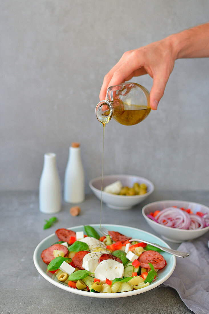 Italienischer Nudelsalat mit Olivenöl, Basilikum, Mozzarella und Oliven