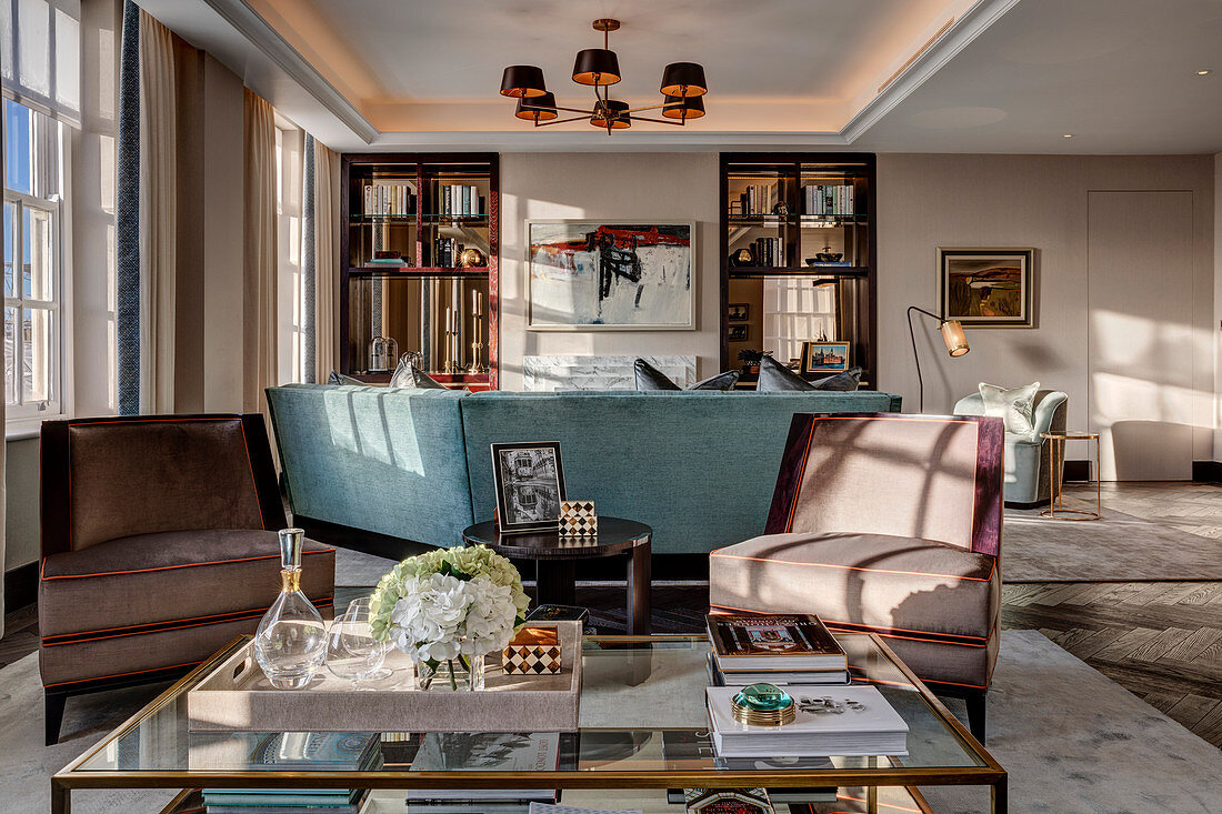 Armchairs around glass coffee table in spacious living area