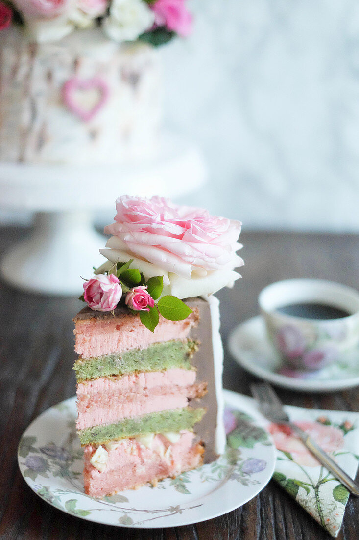 A slice of strawberry and pistachio cake decorated to look like a silver birch