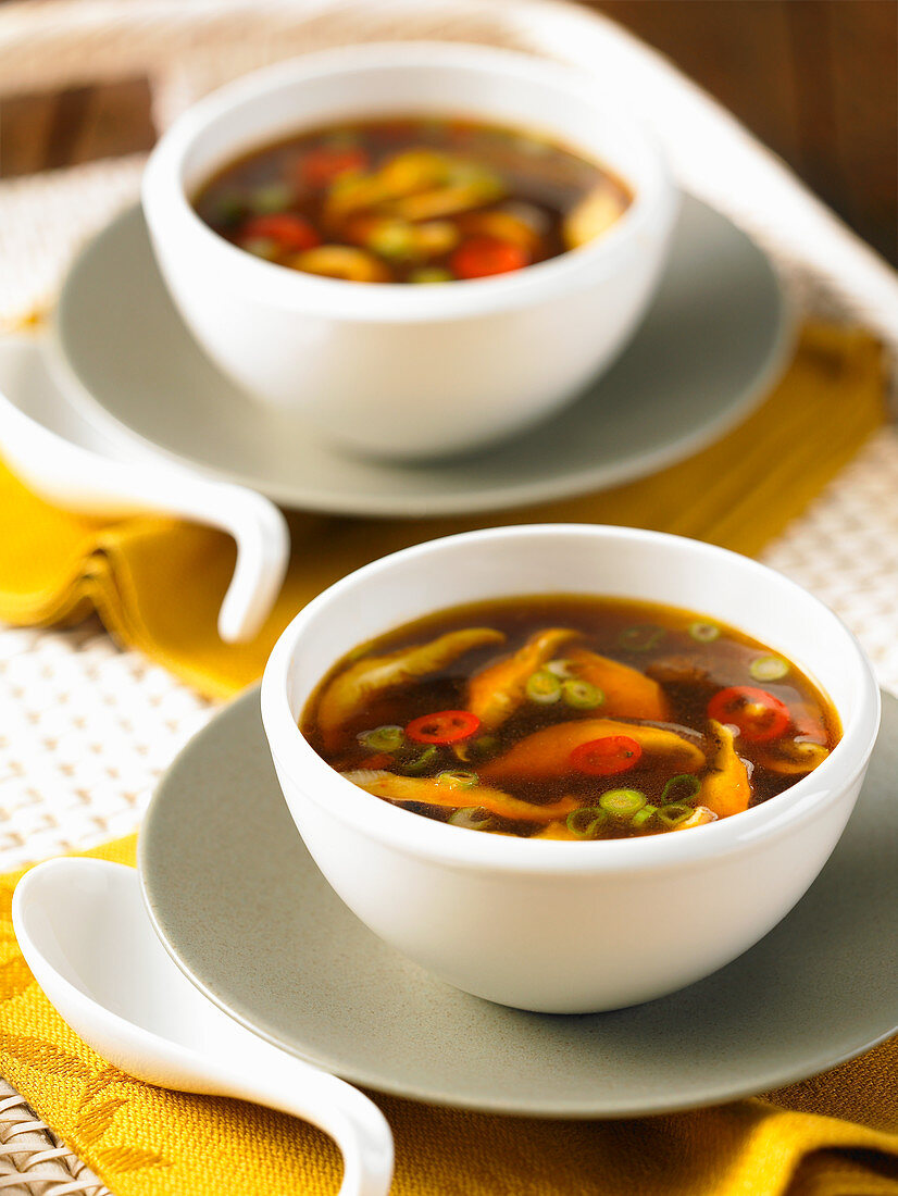 Two bowls of hot and sour Chinese soup with mushrooms