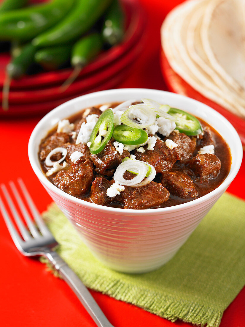 Spicy beef stew, tortillas and green chili peppers