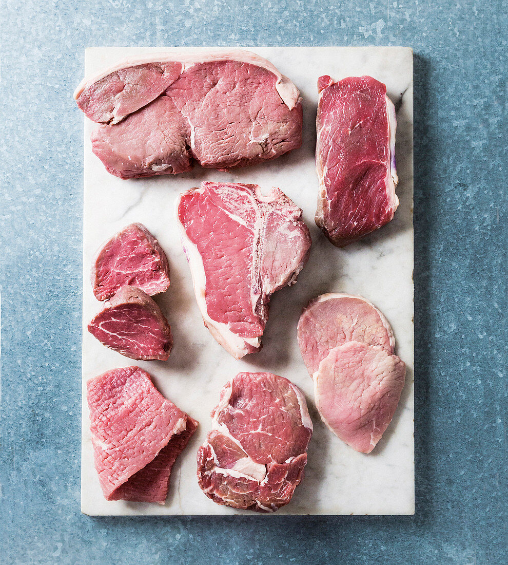 Verschiedene Rindersteaks auf weisser Platte