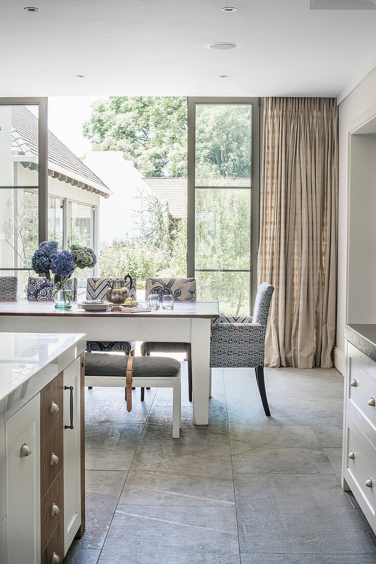 Counter and dining area in front of terrace doors in open-plan kitchen