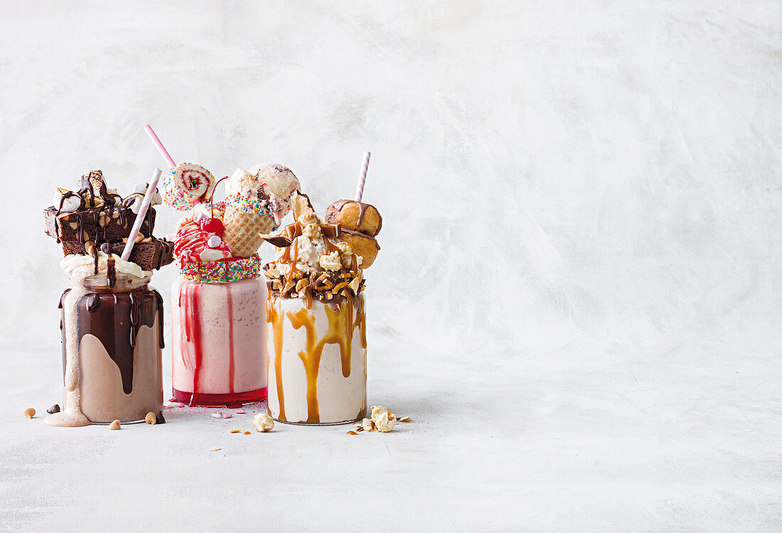 Three different freak shakes against a white background