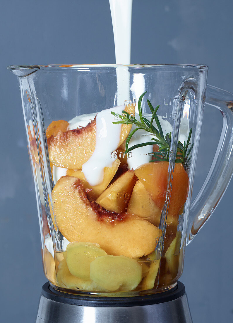 Ingredients for apricot and peach frozen yoghurt with ginger and rosemary in a blender